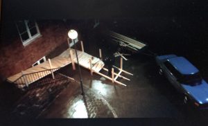 Filmruta. Mörk natt, regn, brädhögar och en framväxande ramp som Ove snickrar.